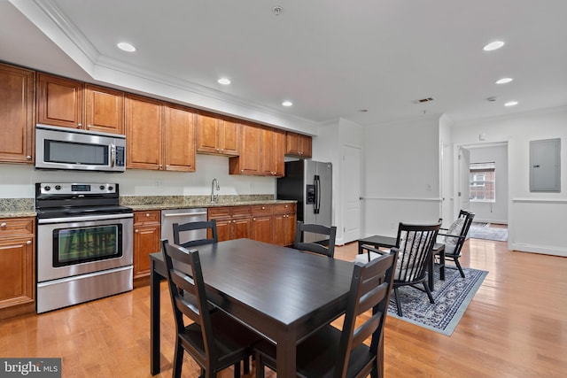 408 Kennedy St NW Unit 202, Washington, DC 20011 - kitchen with appliances with stainless steel finishes, electric panel, brown cabinetry, crown molding, and light wood-type flooring