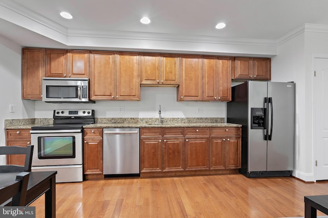 408 Kennedy St NW Unit 202, Washington, DC 20011 - kitchen with appliances with stainless steel finishes, brown cabinetry, light wood-type flooring, a sink, and ornamental molding