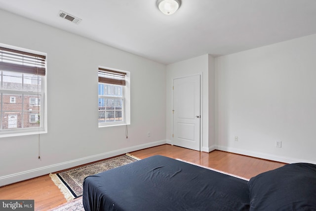 408 Kennedy St NW Unit 202, Washington, DC 20011 - bedroom with wood finished floors, multiple windows, and baseboards
