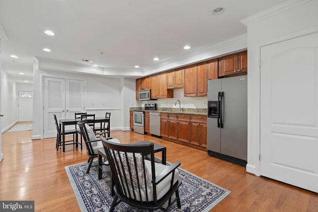 408 Kennedy St NW Unit 202, Washington, DC 20011 - kitchen with stainless steel appliances, crown molding, brown cabinetry, light wood-style flooring, and recessed lighting
