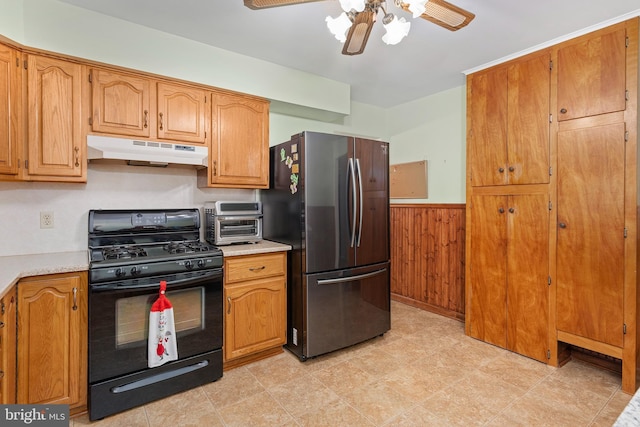 6 Trevett Blvd, Newark, DE 19702 - kitchen featuring under cabinet range hood, gas stove, freestanding refrigerator, a ceiling fan, and wainscoting