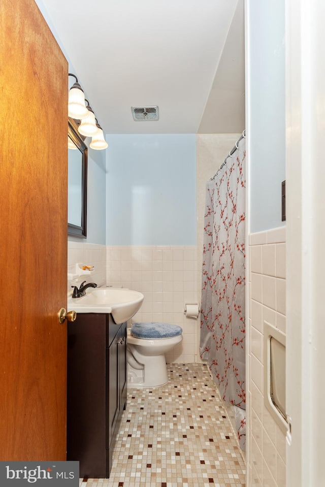6 Trevett Blvd, Newark, DE 19702 - bathroom with tile walls, a wainscoted wall, vanity, tile patterned floors, and toilet