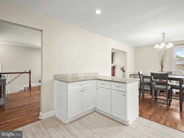 1736 Rhodesia Ave, Fort Washington, MD 20744 - kitchen with white cabinetry, light stone counters, a chandelier, light wood finished floors, and recessed lighting
