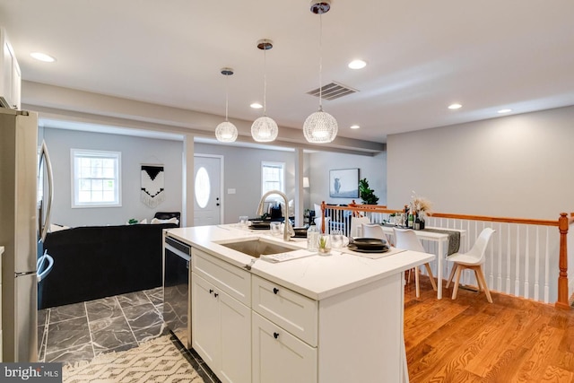 9900 Bird River Rd, Middle River, MD 21220 - kitchen with a sink, stainless steel appliances, white cabinets, recessed lighting, and decorative light fixtures