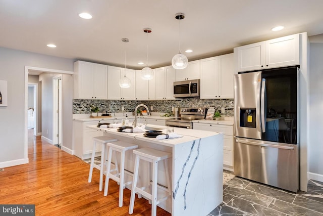 9900 Bird River Rd, Middle River, MD 21220 - kitchen featuring stainless steel appliances, backsplash, white cabinetry, a kitchen island with sink, and recessed lighting