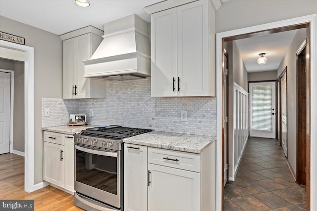 9 Tally Ho Dr, Fredericksburg, VA 22405 - kitchen with custom exhaust hood, gas stove, decorative backsplash, baseboards, and light stone counters