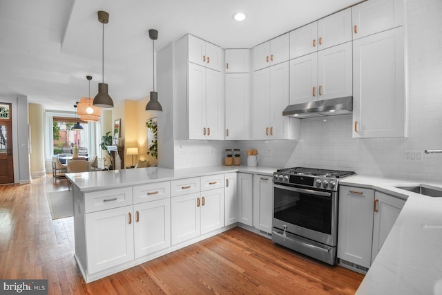 908 Westminster St NW, Washington, DC 20001 - kitchen with stainless steel range with gas cooktop, under cabinet range hood, a peninsula, white cabinets, and recessed lighting