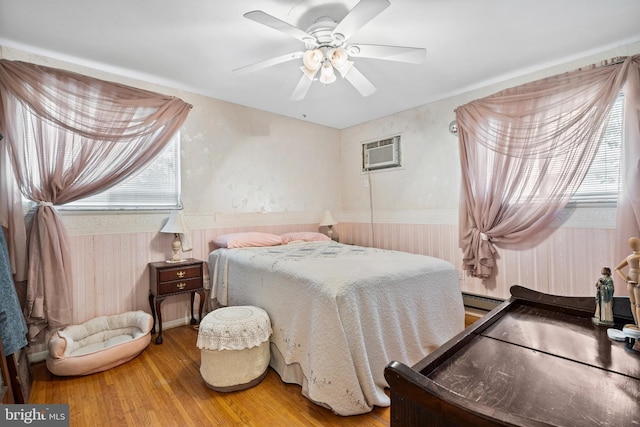 151 Elmtowne Blvd, Hammonton, NJ 08037 - bedroom with wood finished floors, wainscoting, an AC wall unit, ceiling fan, and baseboard heating