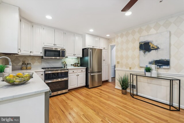 8305 Toll House Rd, Annandale, VA 22003 - kitchen with appliances with stainless steel finishes, wallpapered walls, white cabinetry, ceiling fan, and light wood finished floors