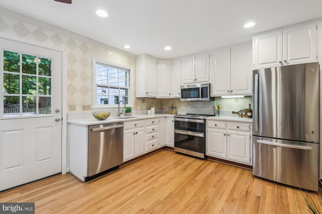 8305 Toll House Rd, Annandale, VA 22003 - kitchen featuring stainless steel appliances, light countertops, light wood finished floors, white cabinets, and recessed lighting