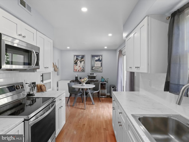 12215 Wye Oak Commons Cir Unit 66, Burke, VA 22015 - kitchen featuring appliances with stainless steel finishes, a sink, backsplash, white cabinetry, and recessed lighting