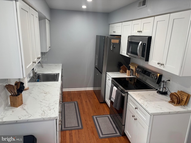 12215 Wye Oak Commons Cir Unit 66, Burke, VA 22015 - kitchen with appliances with stainless steel finishes, baseboards, wood finished floors, white cabinets, and recessed lighting