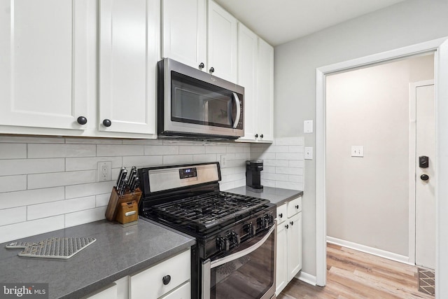3814 Lyndhurst Dr Unit 203, Fairfax, VA 22031 - kitchen featuring stainless steel appliances, dark countertops, white cabinets, light wood-style flooring, and backsplash