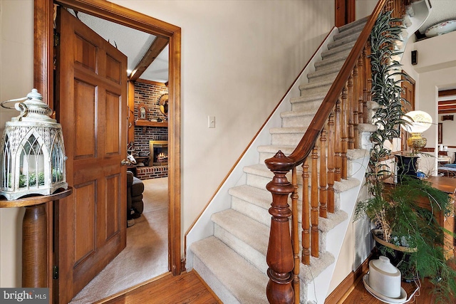 8807 Woodland Ferry Rd, Laurel, DE 19956 - stairs with wood finished floors, a fireplace, baseboards, and beamed ceiling