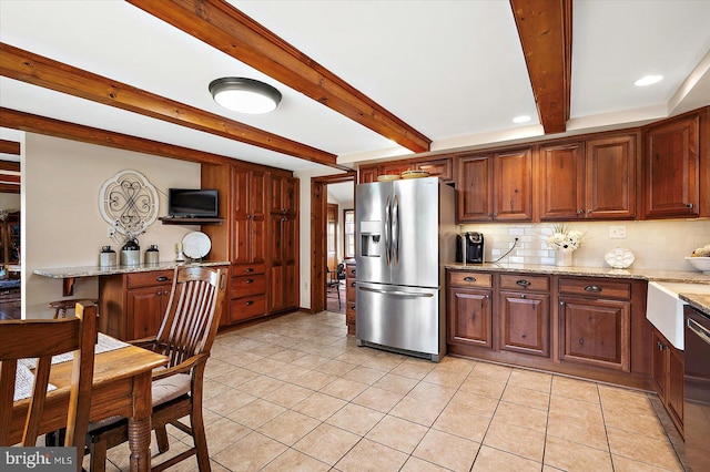 8807 Woodland Ferry Rd, Laurel, DE 19956 - kitchen with appliances with stainless steel finishes, beam ceiling, backsplash, light tile patterned floors, and light stone counters