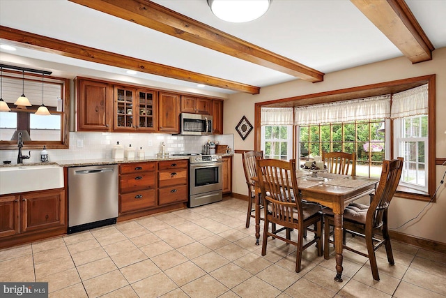 8807 Woodland Ferry Rd, Laurel, DE 19956 - kitchen with stainless steel appliances, a sink, brown cabinets, beam ceiling, and light tile patterned floors