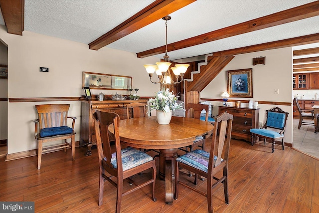 8807 Woodland Ferry Rd, Laurel, DE 19956 - dining room featuring a chandelier, wood finished floors, beamed ceiling, a textured ceiling, and baseboards