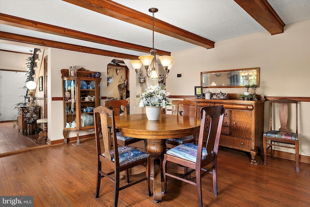 8807 Woodland Ferry Rd, Laurel, DE 19956 - dining room with beamed ceiling, wood finished floors, a chandelier, and a textured ceiling