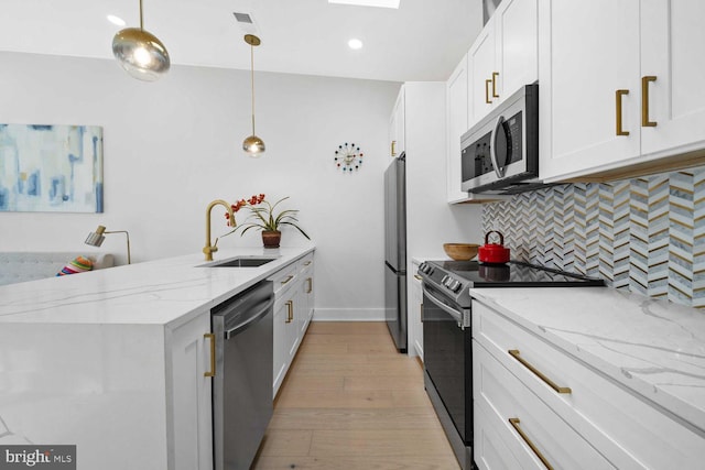 1368 Bryant St NE Unit 4, Washington, DC 20018 - kitchen featuring stainless steel appliances, a sink, a peninsula, tasteful backsplash, and light wood-style floors
