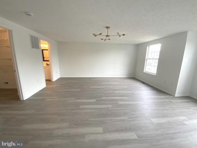 508 Boysenberry Ln, Frederick, MD 21703 - spare room featuring wood finished floors, baseboards, a chandelier, and a smoke detector