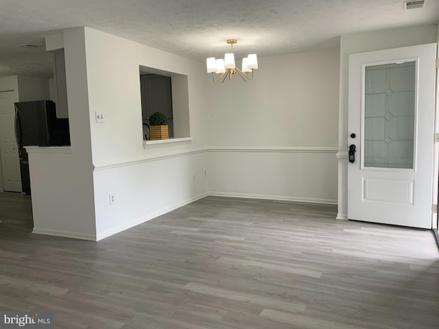 508 Boysenberry Ln, Frederick, MD 21703 - unfurnished dining area featuring wood finished floors, a chandelier, baseboards, and a textured ceiling