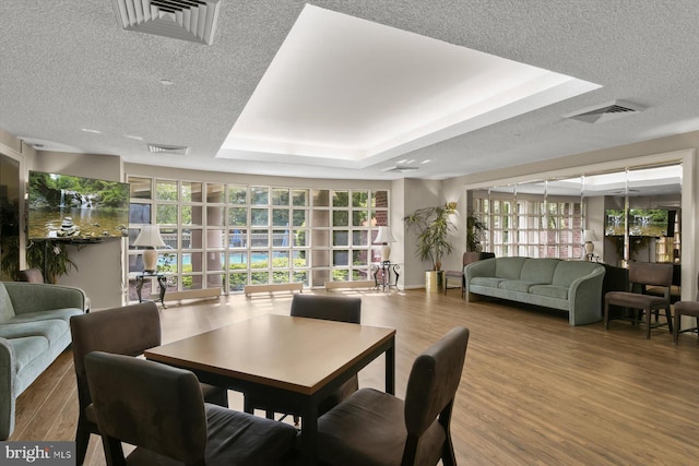 5802 Nicholson Ln Unit 2-407, Rockville, MD 20852 - dining room featuring wood finished floors, plenty of natural light, a raised ceiling, and a textured ceiling
