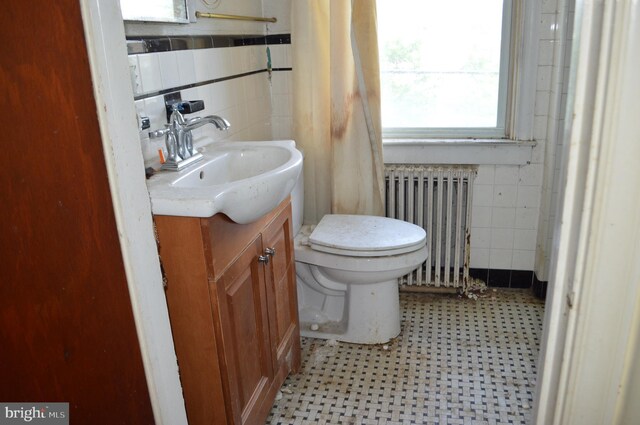 2901 Edison Hwy, Baltimore, MD 21213 - bathroom with radiator heating unit, tile walls, vanity, toilet, and tile patterned floors