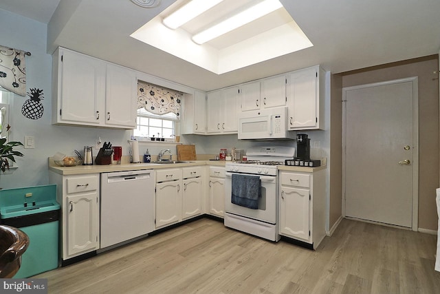 2028 Brookdale Dr, Forked River, NJ 08731 - kitchen featuring white appliances, white cabinetry, light wood-style flooring, and a sink