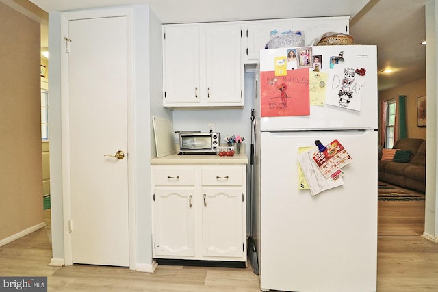 2028 Brookdale Dr, Forked River, NJ 08731 - kitchen with freestanding refrigerator, light wood finished floors, white cabinets, light countertops, and baseboards