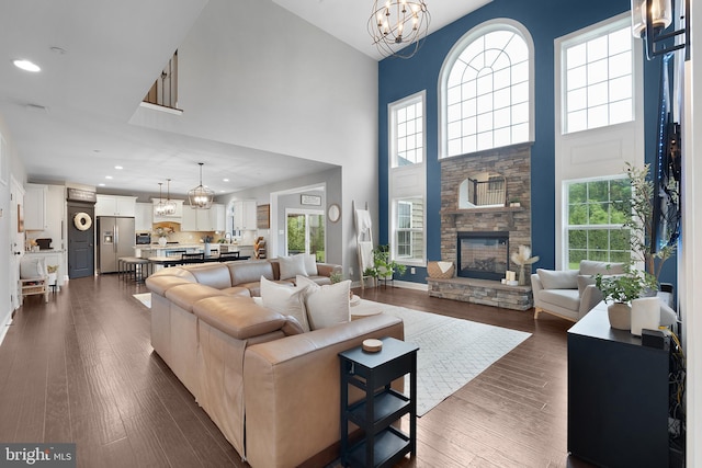 815 Summersweet Ct, Huntingtown, MD 20639 - living area with a chandelier, recessed lighting, a towering ceiling, dark wood-type flooring, and a fireplace