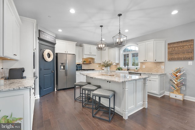 815 Summersweet Ct, Huntingtown, MD 20639 - kitchen with stainless steel appliances, dark wood finished floors, a center island, white cabinets, and decorative backsplash