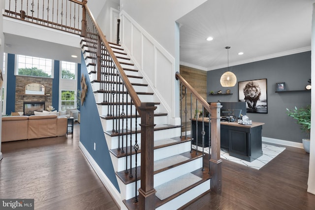 815 Summersweet Ct, Huntingtown, MD 20639 - staircase featuring baseboards, wood finished floors, a fireplace, recessed lighting, and crown molding