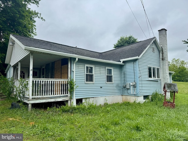 4161 Jacksonville Rd, Howard, PA 16841 - view of property exterior featuring a chimney, roof with shingles, a yard, and covered porch