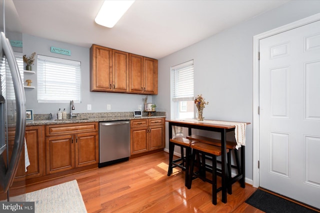 1005 Madison Ct, Annapolis, MD 21403 - kitchen featuring appliances with stainless steel finishes, brown cabinetry, a sink, and light wood-style floors