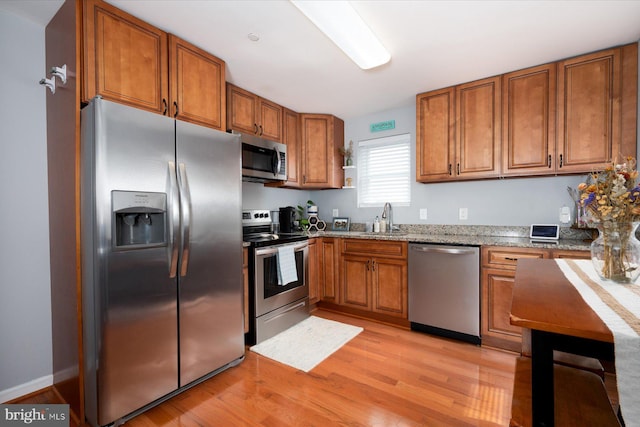 1005 Madison Ct, Annapolis, MD 21403 - kitchen with stainless steel appliances, a sink, brown cabinets, and light wood-type flooring