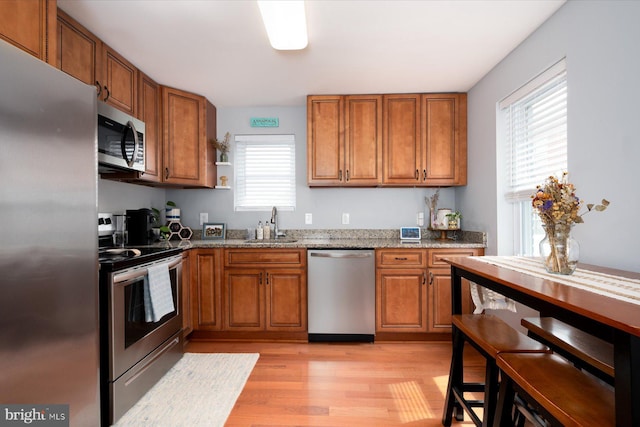 1005 Madison Ct, Annapolis, MD 21403 - kitchen featuring stainless steel appliances, brown cabinets, light wood-style floors, and light stone counters
