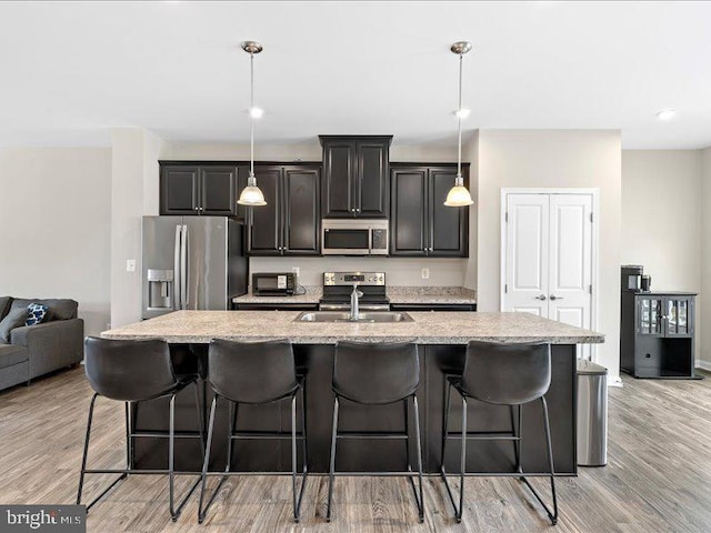 107 Lookout Way, Fredericksburg, VA 22405 - kitchen featuring stainless steel appliances, a large island, a kitchen bar, light stone counters, and recessed lighting