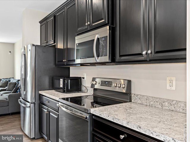 107 Lookout Way, Fredericksburg, VA 22405 - kitchen featuring appliances with stainless steel finishes, dark cabinets, light countertops, light wood-style flooring, and open floor plan
