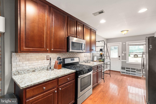 3234 Odonnell St, Baltimore, MD 21224 - kitchen featuring stainless steel appliances, backsplash, light wood-type flooring, light stone counters, and recessed lighting