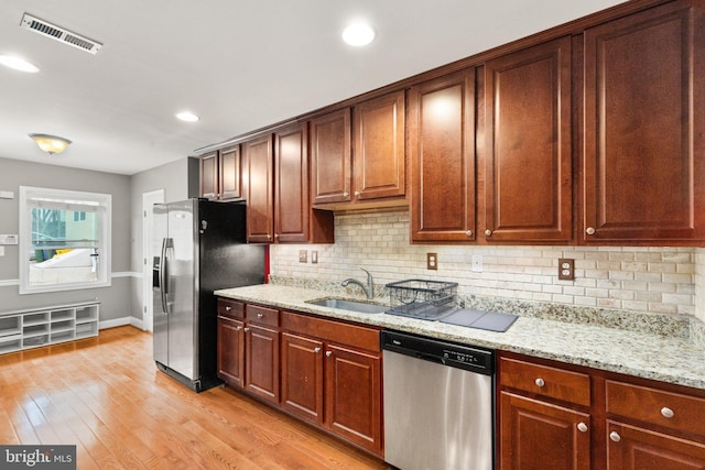 3234 Odonnell St, Baltimore, MD 21224 - kitchen with stainless steel appliances, a sink, tasteful backsplash, light wood finished floors, and recessed lighting