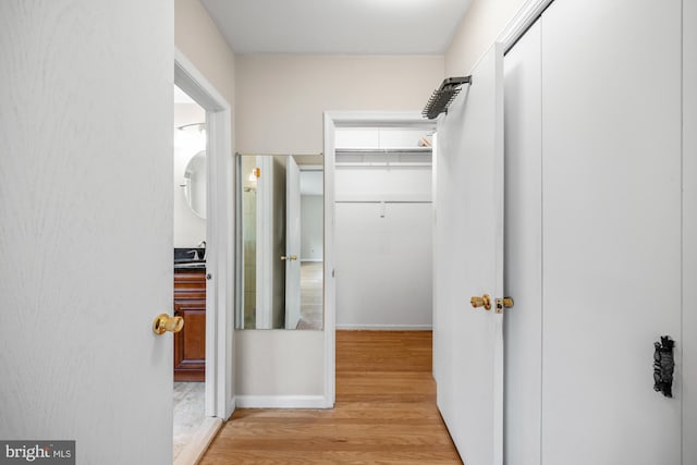 1 Carriage Way, Cinnaminson, NJ 08077 - corridor with light wood-type flooring, a sink, and baseboards