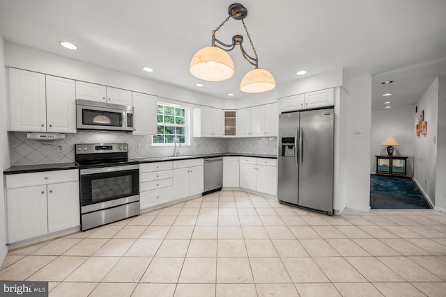 1 Carriage Way, Cinnaminson, NJ 08077 - kitchen featuring appliances with stainless steel finishes, dark countertops, decorative backsplash, hanging light fixtures, and white cabinetry
