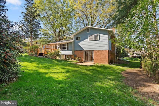1503 Leister Dr, Silver Spring, MD 20904 - rear view of house featuring brick siding, a chimney, a yard, a wooden deck, and central AC