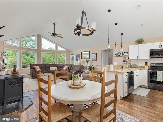 1439 Fiery Run Rd, Linden, VA 22642 - dining room with wood-type flooring, a ceiling fan, a wood stove, and high vaulted ceiling