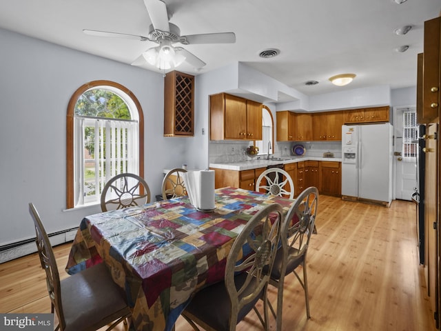 4326 Ranger Ave, Temple Hills, MD 20748 - dining area featuring light wood-style flooring, a ceiling fan, and a baseboard heating unit