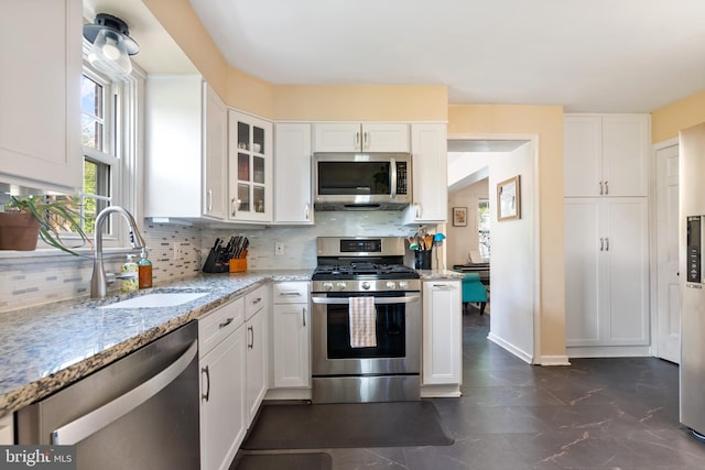 915 Edgewood Dr, Springfield, PA 19064 - kitchen with appliances with stainless steel finishes, a sink, white cabinetry, and backsplash