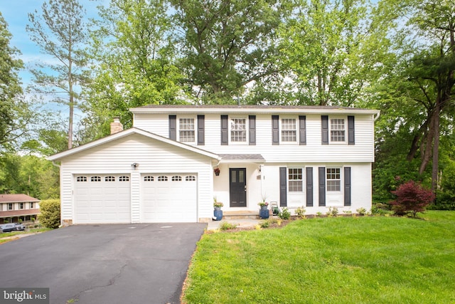 1127 Riva Ridge Dr, Great Falls, VA 22066 - view of front of home with asphalt driveway, a garage, a front lawn, and a chimney