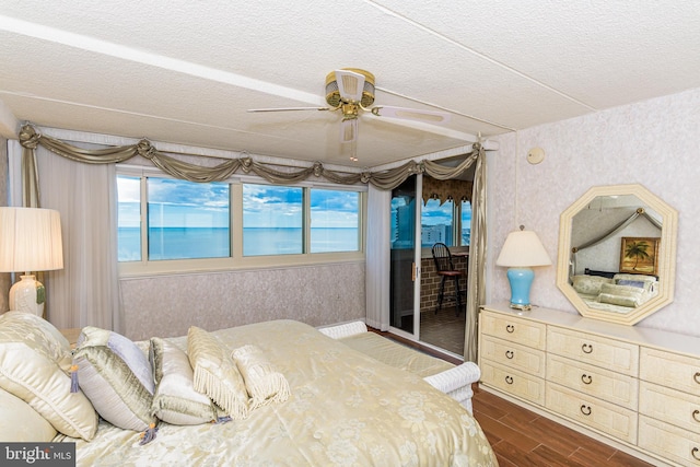 10300 Coastal Hwy Unit 1905, Ocean City, MD 21842 - bedroom featuring wallpapered walls, dark wood-type flooring, access to exterior, multiple windows, and a textured ceiling