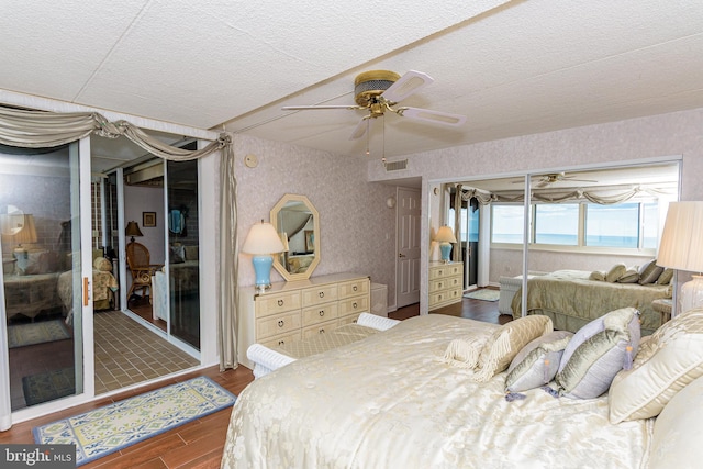 10300 Coastal Hwy Unit 1905, Ocean City, MD 21842 - bedroom with wallpapered walls, dark wood-style flooring, a textured ceiling, and ceiling fan
