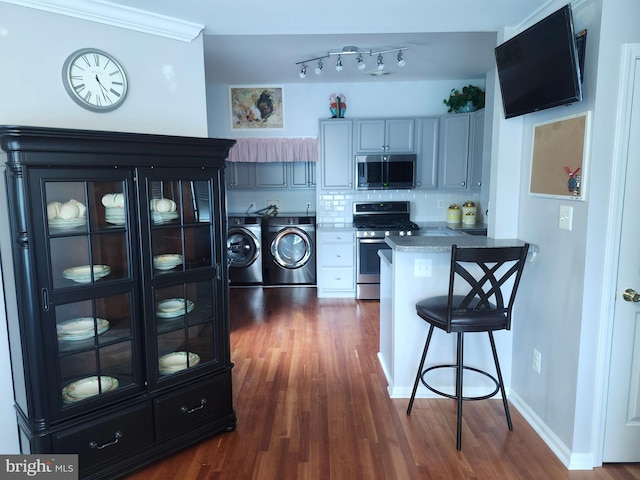 45 Freedom Ln, Bensalem, PA 19020 - kitchen featuring separate washer and dryer, appliances with stainless steel finishes, dark wood-type flooring, and a kitchen breakfast bar